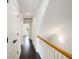 Hallway with white walls, stained wood handrail and black hardware on white paneled doors at 4735 Arco Ln, North Charleston, SC 29418