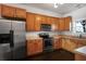 Well-lit kitchen featuring stainless steel appliances, abundant wood cabinetry, and dark hardwood flooring at 4735 Arco Ln, North Charleston, SC 29418