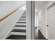 Staircase with dark hardwood steps that lead to a well-lit hallway with crisp white trim at 4735 Arco Ln, North Charleston, SC 29418