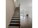 Elegant staircase with dark treads and white risers leads to a bright, open living area with water views at 4735 Arco Ln, North Charleston, SC 29418