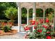 Charming gazebo surrounded by lush landscaping and vibrant red roses creates a serene outdoor retreat at 5024 Scow Ct, Summerville, SC 29485