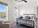 This bedroom features two sunny windows, neutral walls, a ceiling fan and a sitting chair, making it cozy and functional at 508 Helmsman St, Charleston, SC 29492