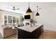 Open kitchen and living area featuring an island with waterfall countertop, modern appliances, and sleek design at 508 Helmsman St, Charleston, SC 29492