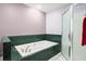 Bathroom features a large soaking tub with green tile surround and a glass-enclosed shower at 520 Givhans Rd, Ridgeville, SC 29472