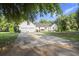 Exterior rear view of a white home featuring a large driveway and backyard at 520 Givhans Rd, Ridgeville, SC 29472