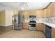 Traditional kitchen featuring stainless steel appliances, wooden cabinetry, and tile flooring at 520 Givhans Rd, Ridgeville, SC 29472