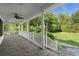 A covered porch with painted railing and a view of the lawn at 520 Givhans Rd, Ridgeville, SC 29472