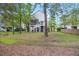 Backyard of two-story home has a wooden fence, mature trees, and a screened in porch, perfect for entertaining at 521 Sanders Farm Ln, Wando, SC 29492