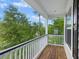 Wooden balcony with white railing overlooking lush trees at 521 Sanders Farm Ln, Wando, SC 29492
