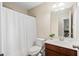 Clean, bright bathroom with wood vanity and shower with curtain at 521 Sanders Farm Ln, Wando, SC 29492