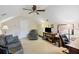 Cozy bonus room with neutral carpet, ceiling fan, comfortable chair, couch, television and desk space, perfect for a home office or den at 521 Sanders Farm Ln, Wando, SC 29492