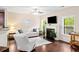 Bright living room with large windows, a fireplace, hardwood floors, a white sofa, and white walls at 521 Sanders Farm Ln, Wando, SC 29492