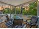 Relaxing screened-in porch with wood floors, outdoor seating, and lovely view of lush trees at 521 Sanders Farm Ln, Wando, SC 29492