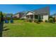 A sprawling backyard with lush lawn, fire pit with Adirondack chairs, and a charming covered patio in the distance at 521 Yellow Tower Ter, Charleston, SC 29412
