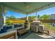 Inviting covered patio with comfortable seating, ceiling fan, grill, and view of the fenced yard and neighborhood beyond at 521 Yellow Tower Ter, Charleston, SC 29412