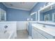 This bright blue bathroom features tile flooring and a double sink vanity with modern light fixtures at 522 Antebellum Ln, Mount Pleasant, SC 29464
