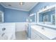 Bright blue bathroom features tile flooring and a double sink vanity with modern light fixtures at 522 Antebellum Ln, Mount Pleasant, SC 29464