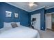 This modern bedroom features a ceiling fan, blue walls, and two framed botanical art pieces at 522 Antebellum Ln, Mount Pleasant, SC 29464
