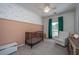 Adorable Bedroom with a crib, white armchair, half wallpapered walls and natural light from window at 522 Antebellum Ln, Mount Pleasant, SC 29464
