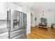 Stainless steel refrigerator and white cabinets complement the hardwood floors and flow into the nearby dining area at 522 Antebellum Ln, Mount Pleasant, SC 29464