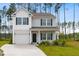 Charming two-story home featuring a well-maintained lawn and inviting entrance with a concrete driveway and landscaping at 525 Purple Finch Rd, Summerville, SC 29486