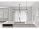 Sunlit kitchen island with modern pendant lighting and sleek appliances offers a seamless culinary experience at 525 Purple Finch Rd, Summerville, SC 29486