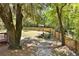 Fenced backyard with fire pit, wooden bench, and mature trees at 5471 Rising Tide, North Charleston, SC 29420
