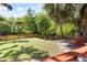 Private grassy backyard with a fire pit, bench swing, and mature trees at 5471 Rising Tide, North Charleston, SC 29420
