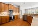 Well-equipped kitchen with wood cabinets, granite countertops, stainless steel appliances, and hardwood flooring at 5471 Rising Tide, North Charleston, SC 29420