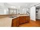 Open kitchen with wooden cabinets, granite countertops, stainless steel sink, and hardwood floors at 5471 Rising Tide, North Charleston, SC 29420