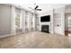 Spacious living room with tile flooring, large windows with sheer curtains, and a fireplace with built-in shelving at 5471 Rising Tide, North Charleston, SC 29420