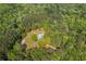 Aerial shot highlighting a home with a classic roof design, set amidst a vibrant, dense forest, evoking natural beauty at 5950 Kelseys Mill Rd, Ravenel, SC 29470