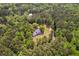 Aerial view of a secluded house surrounded by dense forest with a small stream flowing nearby, offering tranquility at 5950 Kelseys Mill Rd, Ravenel, SC 29470
