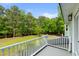A backyard view from a deck with green grass and a wooded area at 5950 Kelseys Mill Rd, Ravenel, SC 29470