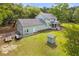 Rear exterior of this lovely home with a two-car garage and storage shed in the large yard surrounded by mature trees at 5950 Kelseys Mill Rd, Ravenel, SC 29470