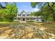 Charming two-story home with a large front porch and well-manicured lawn surrounded by mature trees at 5950 Kelseys Mill Rd, Ravenel, SC 29470