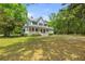 Two-story home featuring classic architecture with a spacious front yard and mature trees in a serene setting at 5950 Kelseys Mill Rd, Ravenel, SC 29470