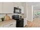 Updated kitchen with white cabinets, stone countertops and black appliances at 5950 Kelseys Mill Rd, Ravenel, SC 29470
