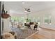 Sunlit living room with large windows, stylish seating, and a cozy fireplace, perfect for relaxation and gatherings at 5950 Kelseys Mill Rd, Ravenel, SC 29470