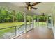 Relaxing screened porch with wood floors, ceiling fans, and views of the backyard at 5950 Kelseys Mill Rd, Ravenel, SC 29470