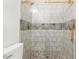 This spacious shower features a stone tile floor, glass door, and convenient in-shower shelf at 5950 Kelseys Mill Rd, Ravenel, SC 29470