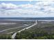Scenic aerial view of a winding highway amidst marshlands and lush greenery, under a partly cloudy sky at 60 Fenwick Hall Aly # 937, Johns Island, SC 29455