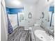 Well-lit bathroom with blue accent wall, a tub, and ample storage space for accessories at 60 Fenwick Hall Aly # 937, Johns Island, SC 29455