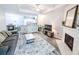 Open-concept living room with modern fireplace, wood floors, and abundant natural light flowing from nearby kitchen at 60 Fenwick Hall Aly # 937, Johns Island, SC 29455