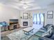 Sunlit living room with a tiled fireplace, sleek furniture, and large windows offering bright light at 60 Fenwick Hall Aly # 937, Johns Island, SC 29455