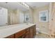 Bathroom with tile floor, large vanity with dark cabinets and matching framed mirror at 9609 Portal Ct, Summerville, SC 29485