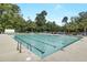 Community pool, surrounded by trees, features chairs and a pool house at 9609 Portal Ct, Summerville, SC 29485