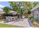 This backyard patio includes an outdoor dining set, grill, shade umbrella, and well-manicured lawn at 9670 Pebble Creek Blvd, Summerville, SC 29485