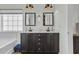 Charming bathroom features a double vanity, framed mirrors, sconce lighting, and a garden window over a tub at 9670 Pebble Creek Blvd, Summerville, SC 29485