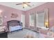 Pink bedroom features a crib, armchair, two windows and carpet at 9670 Pebble Creek Blvd, Summerville, SC 29485